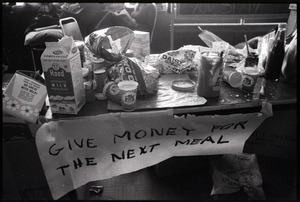 Table at the Sala de Puerto Rico with food and sign reading 'Money for next meal' : Vietnam War sanctuary at MIT