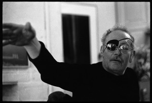 W. Eugene Smith, seated at a desk in his home