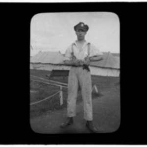 Soldier posing in front of camp