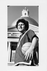 Suffolk University men's basketball player Chris Tsiotos posed in front of the State House in downtown Boston, holding baskeball in left hand, looking at the camera, circa 1978-1979