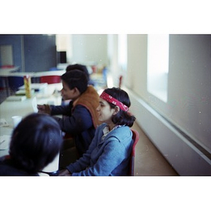Four teenagers seated in a classroom at La Alianza Hispana, Boston