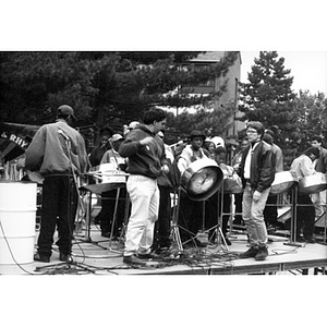 Alex Alvear (right, front) on an outdoor stage with a youth steel drum band.