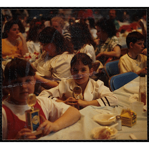 Two girls, seated at a table, pose with their trophies at a Boys and Girls Club awards event