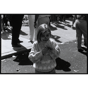 A girl with her face painted looks at the camera while holding a shaved ice at the Boys and Girls Clubs of Boston 100th Anniversary Celebration Street Fair