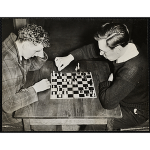 Two teenage boys play chess