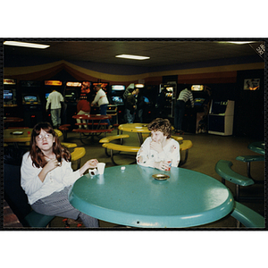 Two girls sit at a table during a Tri-Club trip to Roller World