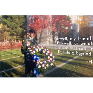 A man in uniform is reflected on a quotation on the Veterans Memorial at the dedication ceremony
