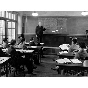 A professor points at a blackboard while teaching an accounting class for the School of Business Administration