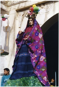 Large female statue atop a coffin in a funeral procession and Fiesta de Ano Nuevo celebration