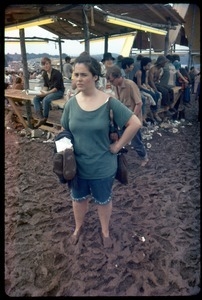 Woman standing in ankle-deep mud at the Woodstock Festival