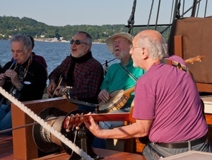 David Amram, Raffi, Pete Seeger, and Peter Yarrow (from left) playing music aboard the Mystic Whaler, during the Clearwater Festival