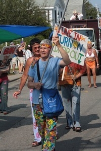 Parade marcher with sign reading 'Tune in, turn on, drop out' : Provincetown Carnival parade