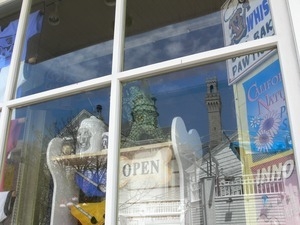 Reflection of the Pilgrim Monument in a store window on Commercial Street, Provincetown