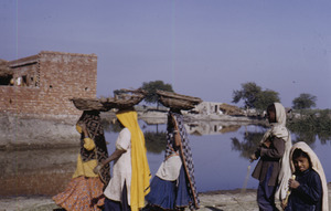 Women approach a village in Delhi