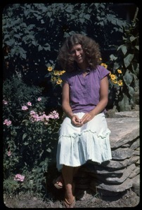 Amy Wainer seated on a stone wall, Montague Farm Commune