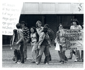 Board of Trustees fee increase demonstration: protestors holding sign and banner, marching from the Student Union to the Whitmore Administration Building