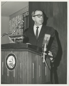 Unidentified man speaking at a podium featuring the ICD logo