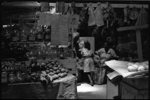 Interior of a market stall in the old marketplace, with woman and young girl, Belize City