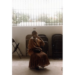 Woman sitting in a folding chair in a room.