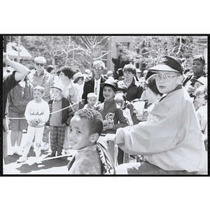 Children and adults watching a game at the Boys and Girls Clubs of Boston 100th Anniversary Celebration Street Fair