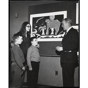 Barbara Falcon, art instructor at the South Boston Boys' Club, standing with Michael Powell and Blaine Campbell while talking with Dwight C. Shepler, Chairman of the Art Advisory Committee, at the Boys' Clubs of Boston Art Exhibit at the Museum of Science