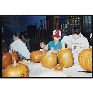 Children carve pumpkins at a Halloween event