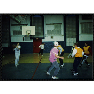 Boys play basketball on an indoor court