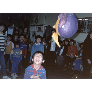 Guest swings at a piñata during the Chinese Progressive Association's children's party