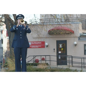 A man in uniform plays trumpet at the Veterans Memorial dedication ceremony