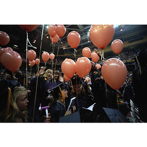 Class of 1994 graduates seated in the stands holding balloons at commencement