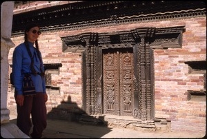 Sandi Sommer beside ornately carved wooden door in Bhaktapur