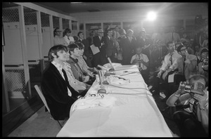 Ringo Starr, Paul McCartney, John Lennon, and George Harrison (l. to r.) seated at a table during a Beatles press conference