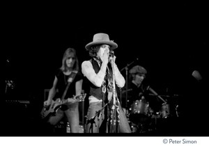 Bob Dylan performing on harmonica at the Harvard Square Theater, Cambridge, with the Rolling Thunder Revue