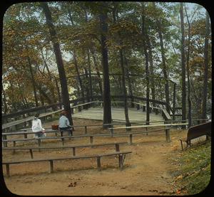 Outdoor theater on Sugar Loaf (boy and girl sitting on wooden benches)