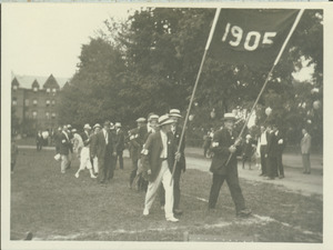 Members of the class of 1905 walking outside and holding a 1905 banner