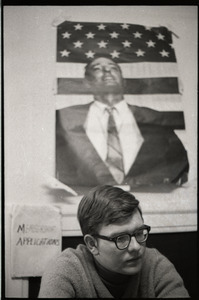 Young Americans for Freedom (YAF) office: YAF member seated in front of poster of William F. Buckley