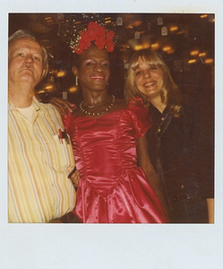 A Photograph of Marsha P. Johnson in a Pink Dress Posing with Randy Wicker and Suzanne Phillips