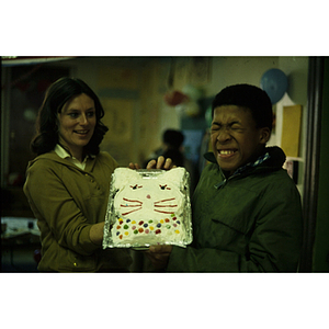 Child posing with a decorated cake