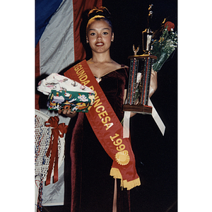The second princess holds a trophy and presents at the Festival Puertorriqueño