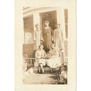 A group of women pose on the steps of an enclosed gazebo