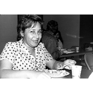 Woman eating during a community gathering.