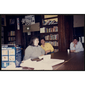 Staff members seated around a table with an unwrapped gift