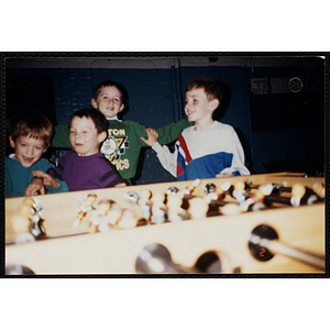 Four boys play foosball