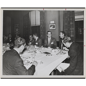 Committee members eat and converse at a Boys' Club event