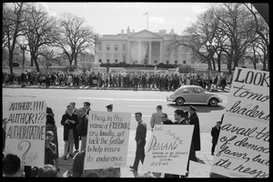 Counter-protesters in front of the White House across the street from the antiwar demonstration, carrying signs reading 'They in the name of freedom cry loudly...' and 'We SWINE demand removal of all troops no later than 11:28 am 11-28-1965': Washington Vietnam March for Peace