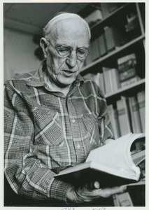 Charles P. Alexander holding an open book