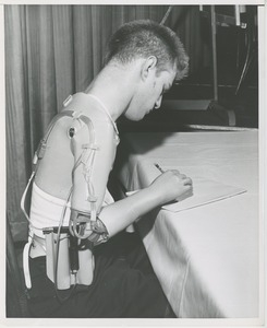 William Anderson writing with his prosthetic arm