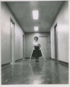 Unidentified woman with cerebral palsy walking on crutches