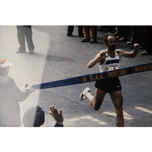 Man running through finish line at Boston Athletic Association (BAA) marathon