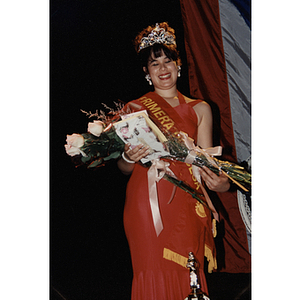 Chamely Toro holds a bouquet of flowers and wears a crown at the Festival Puertorriqueño